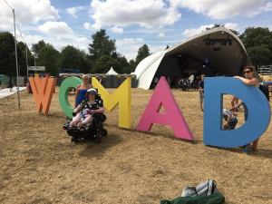 Lucy in front of WOMAD sign